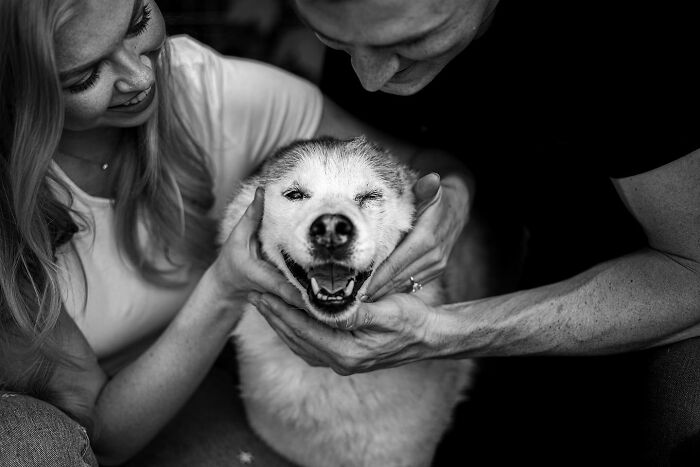 Couple sharing a tender moment with their dog, capturing touching final moments between pets and their humans outdoors.