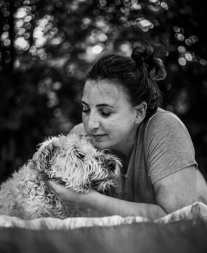 Woman tenderly holding and touching her dog's face, capturing a touching moment between pets and their humans.