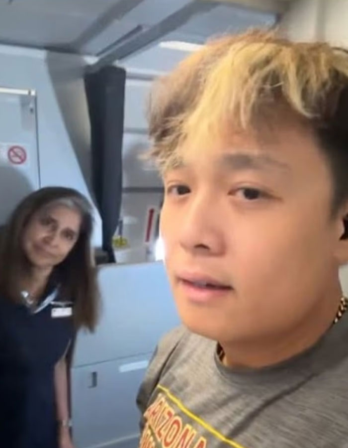 Young man caught vaping on plane with flight attendant in background during confrontation inside aircraft cabin Young man caught vaping on plane with flight attendant in background during confrontation inside aircraft cabin
