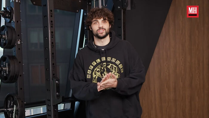 Young man with curly hair wearing a black hoodie in a gym setting, related to celebrities Hollywood tried to make leading stars