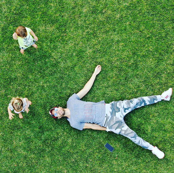 Man lying on grass with two children nearby, highlighting Anna Kournikova pregnancy announcement with Enrique Iglesias. Man lying on grass with two children nearby, highlighting Anna Kournikova pregnancy announcement with Enrique Iglesias.
