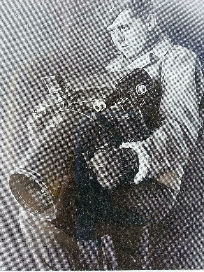 World War II soldier holding a large camera to capture historical photos with interesting backstories.
