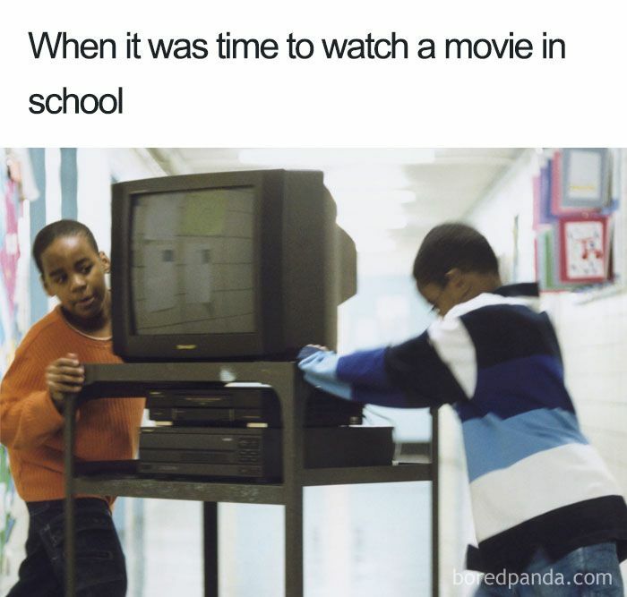 Two boys pushing a TV cart with a VCR in a school hallway, evoking 90s kids nostalgia.