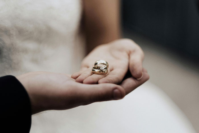 Close-up of a woman holding wedding rings, reflecting on separation and divorce differences with her husband. Close-up of a woman holding wedding rings, reflecting on separation and divorce differences with her husband.