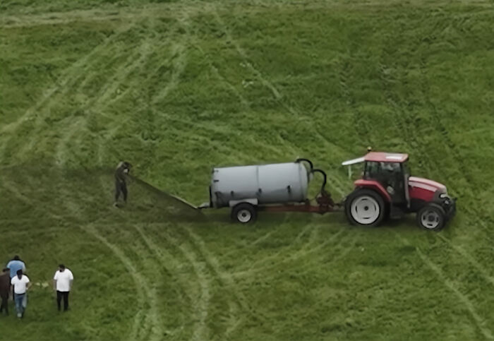 Farmer spraying manure from tractor in field with people nearby, capturing viral story and photographer’s perspective. Farmer spraying manure from tractor in field with people nearby, capturing viral story and photographer’s perspective.