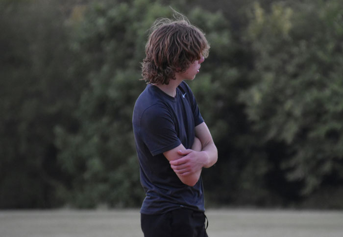 Teen boy standing outside with arms crossed, looking away, illustrating mom telling teen son to leave home regret story. Teen boy standing outside with arms crossed, looking away, illustrating mom telling teen son to leave home regret story.