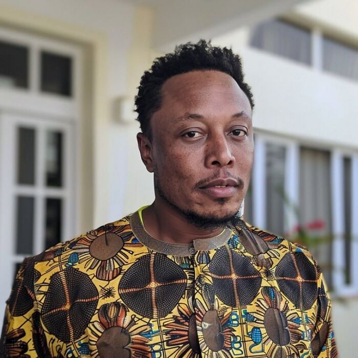 40-year-old Kenyan man posing outdoors in vibrant patterned shirt amid claims of being Elon Musk's eldest son. 40-year-old Kenyan man posing outdoors in vibrant patterned shirt amid claims of being Elon Musk's eldest son.