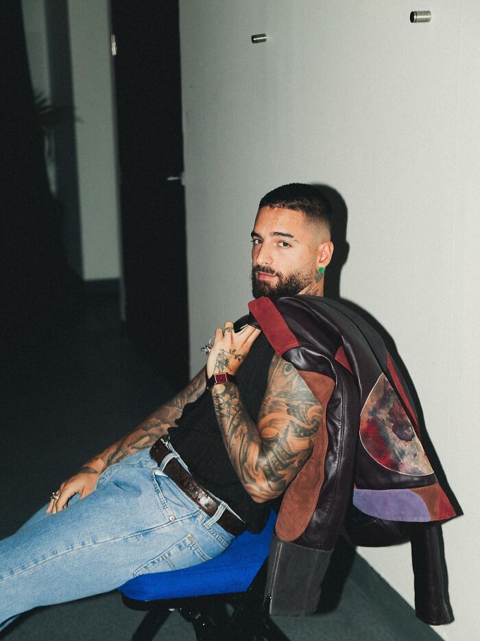 Singer with tattoos and a leather jacket casually sitting, embodying the vibe before abruptly stopping concert for irresponsible mom. Singer with tattoos and a leather jacket casually sitting, embodying the vibe before abruptly stopping concert for irresponsible mom.