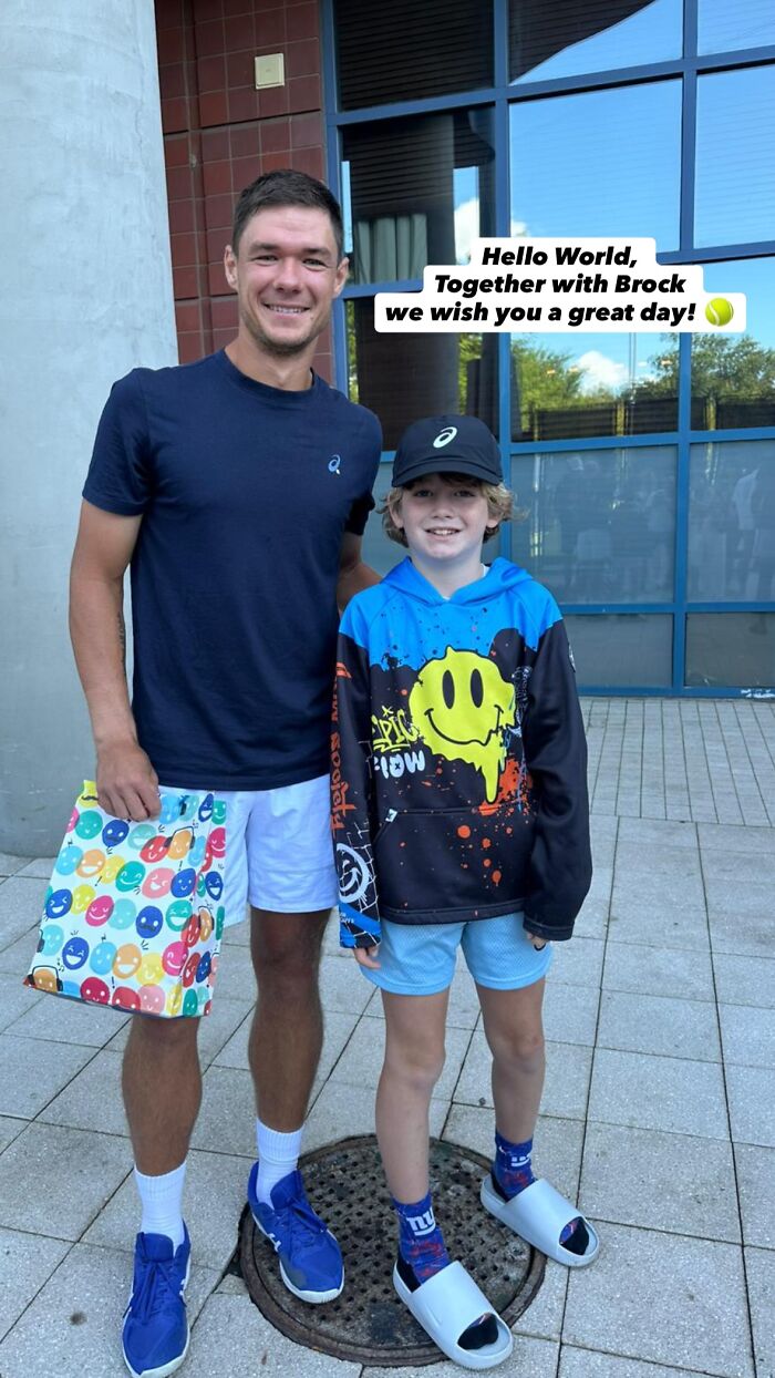Polish CEO posing with a young fan outside a building, related to the infamous US Open hat snatcher incident. Polish CEO posing with a young fan outside a building, related to the infamous US Open hat snatcher incident.