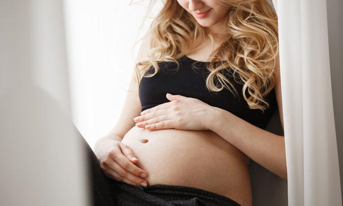 Pregnant woman gently holding her belly, reflecting on family demands and sister needing money more than her. Pregnant woman gently holding her belly, reflecting on family demands and sister needing money more than her.