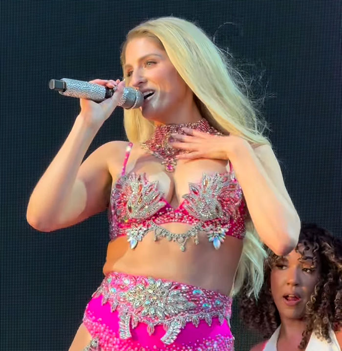 Meghan Trainor performing on stage in a sparkling pink outfit, looking stunning and unrecognizable to fans. Meghan Trainor performing on stage in a sparkling pink outfit, looking stunning and unrecognizable to fans.