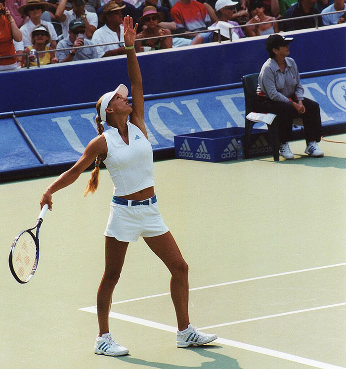 Anna Kournikova playing tennis in white sportswear during a match, related to pregnancy announcement with Enrique Iglesias. Anna Kournikova playing tennis in white sportswear during a match, related to pregnancy announcement with Enrique Iglesias.