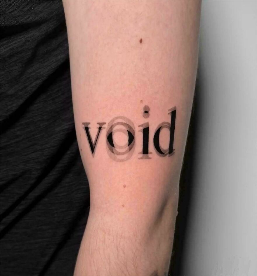 Tattoo on arm with the word void designed with a blurred, layered effect showcasing creative typography.