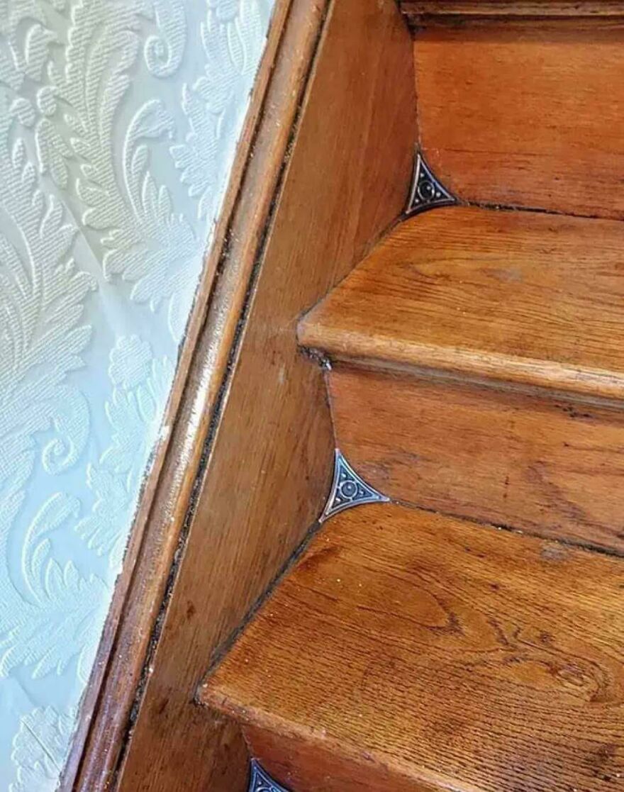 Wooden stairs with unique decorative metal corner brackets, showcasing interesting design details from an online community.