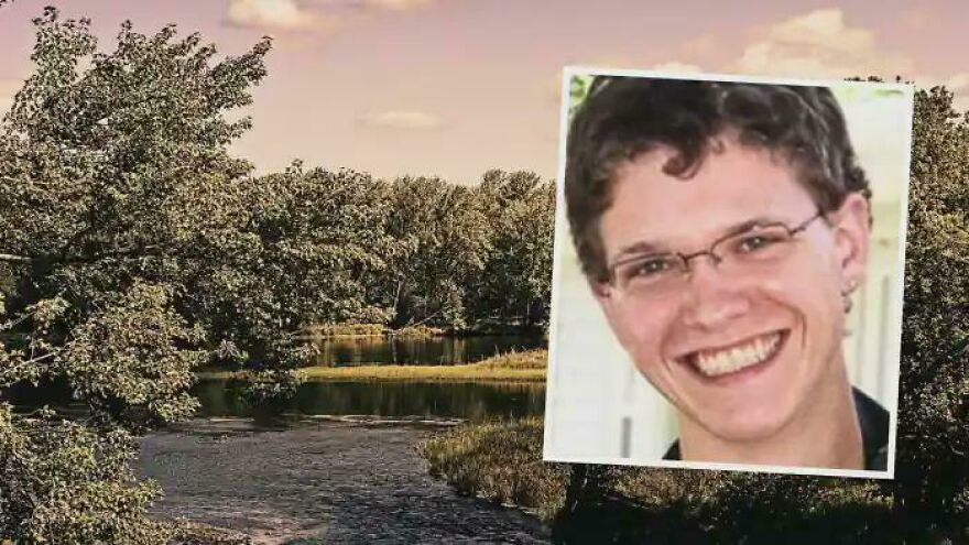 Smiling person wearing glasses over a scenic river landscape with trees under a cloudy sky, highlighting interesting content.