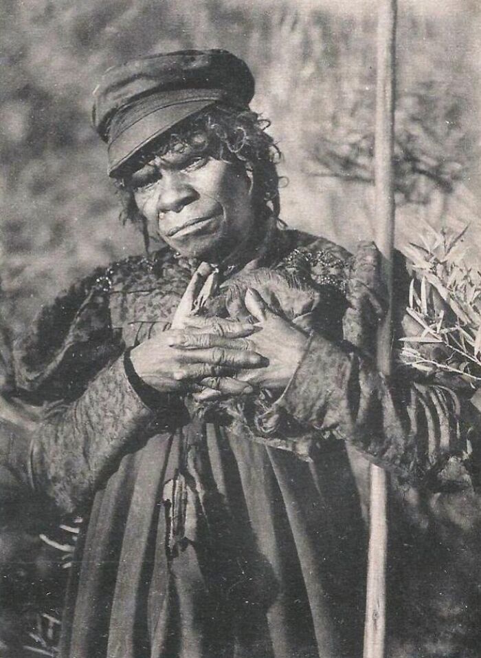 Indigenous Australian woman from the 1900s holding a small animal, captured in a rare historical black and white photo.