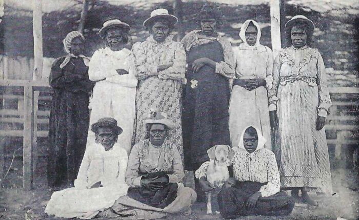 Group of Indigenous Australians from the 1900s posing outdoors, showcasing rare glimpses into early 20th century life.