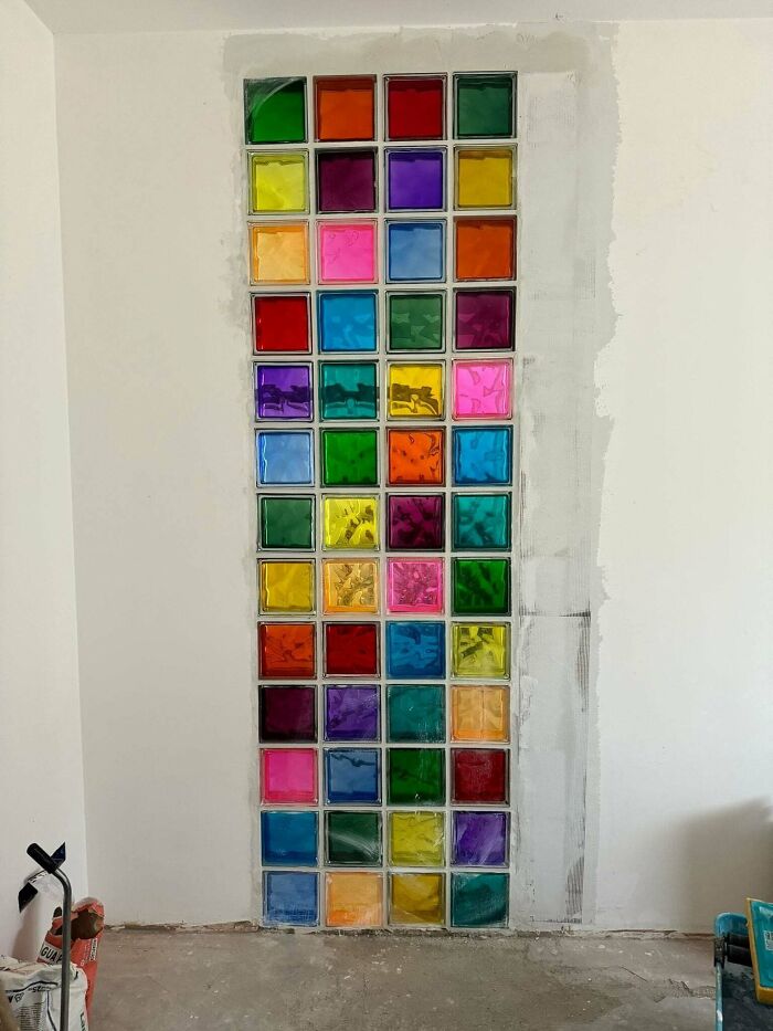 Colorful glass block wall installation in a home corner, showcasing a unique and proud home decorating feature.