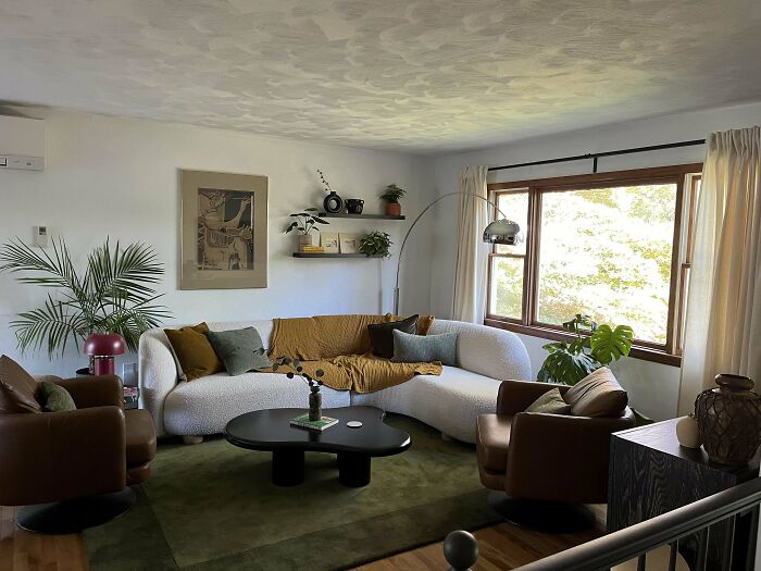 Cozy living room corner with modern decor, plants, and natural light showcasing home decorating pride.