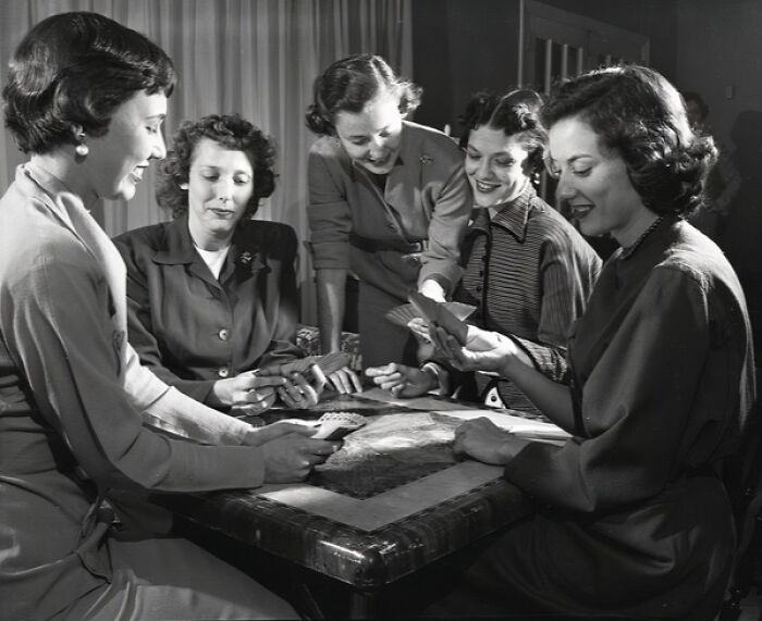 Group of women playing cards indoors, capturing everyday life in 1950s Florida with vintage clothing and hairstyles.