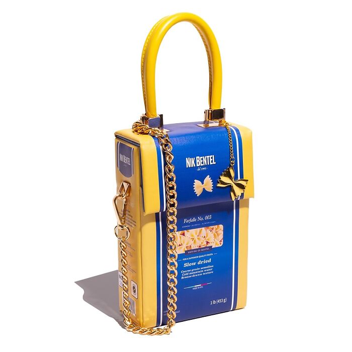 Unique fashion accessory by Nik Bentel designed as a pasta box handbag with gold chain and butterfly charm.