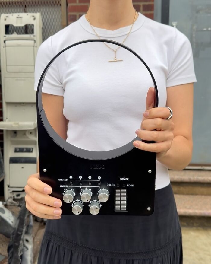 Person holding a unique fashion accessory blending everyday objects with vintage stereo controls and design elements.