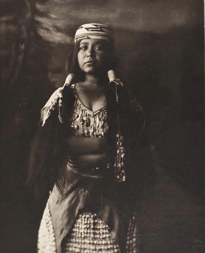 Native woman from a Native tribe in traditional attire, captured by a photographer showcasing strength in the 1900s.