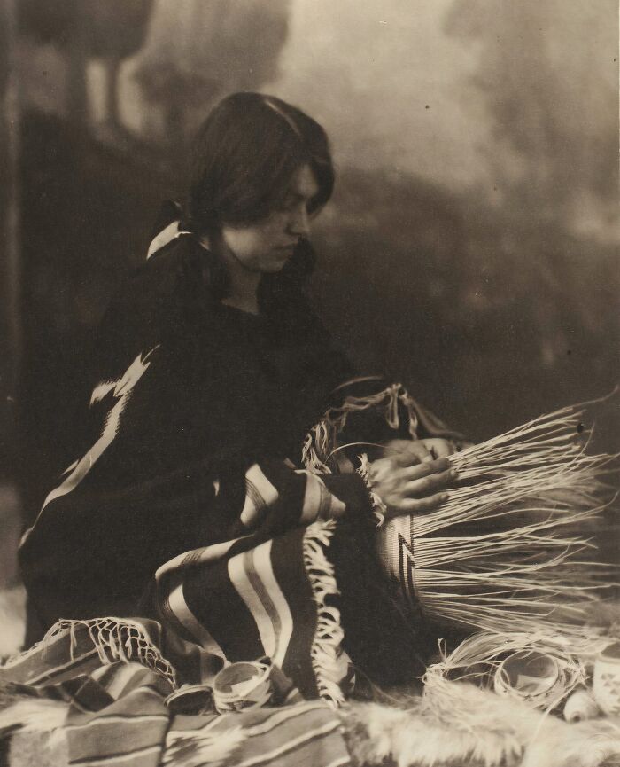 Native tribes woman weaving a basket by hand, showcasing traditional craft in early 1900s Native tribes photography.