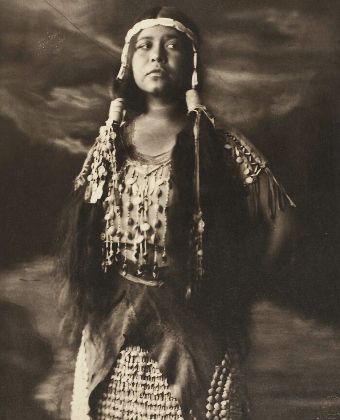 Native tribes person in traditional clothing captured in a powerful historical portrait from the 1900s by a notable photographer.
