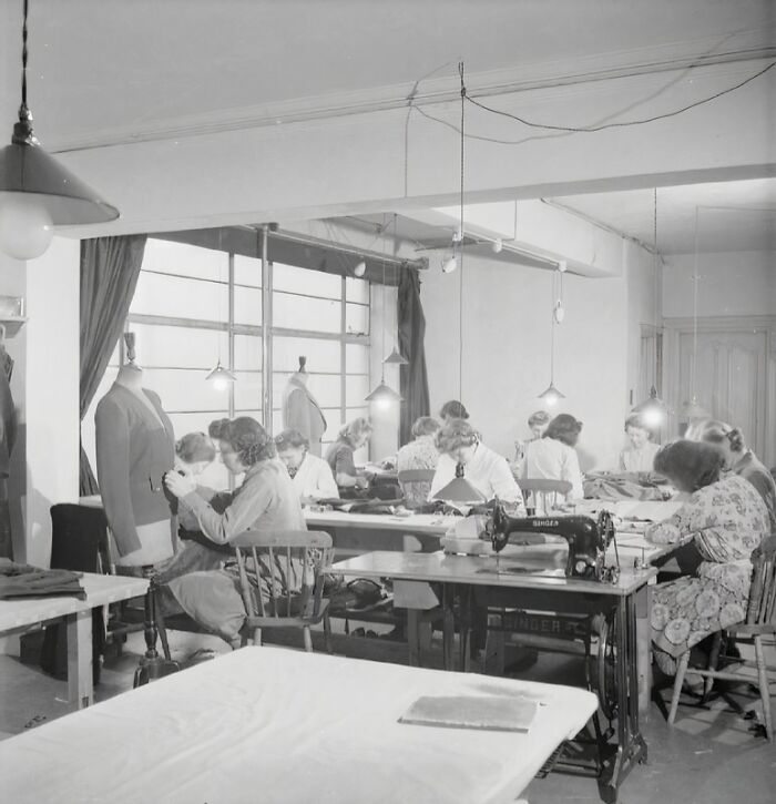 British women sewing and tailoring garments in a workshop, maintaining style during WWII clothing restrictions.