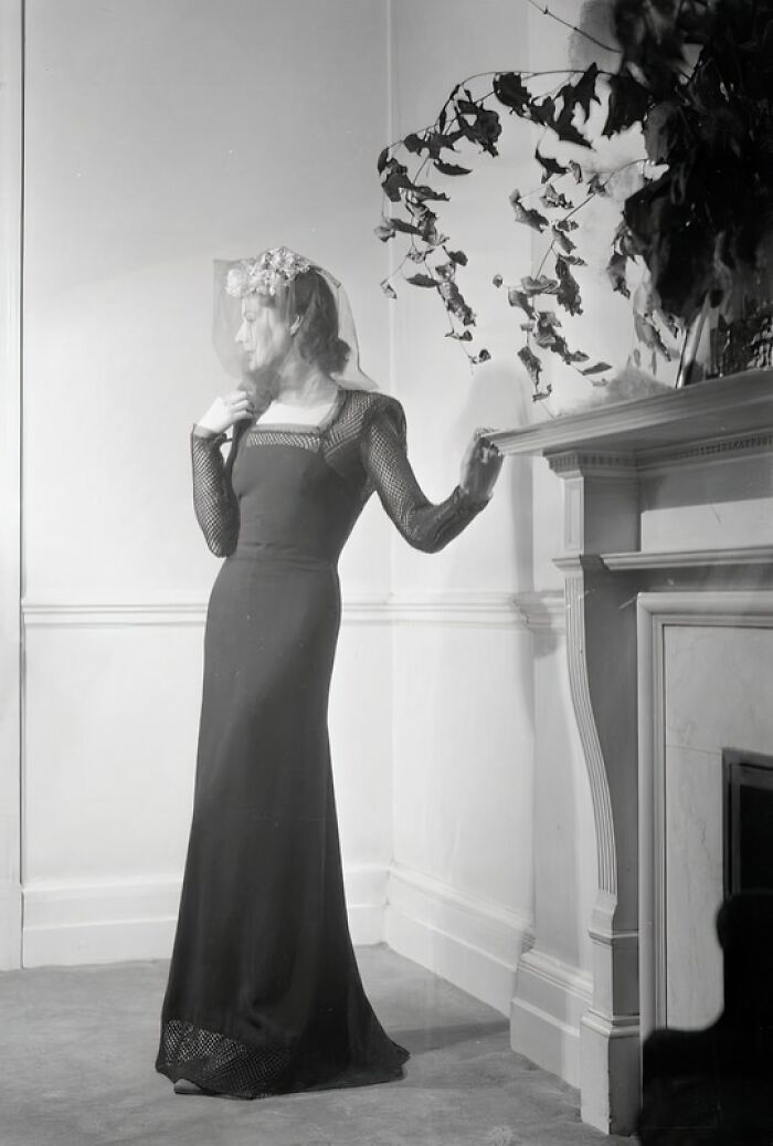 British woman in a stylish WWII-era dress with lace sleeves and veil, showcasing fashion despite wartime restrictions.