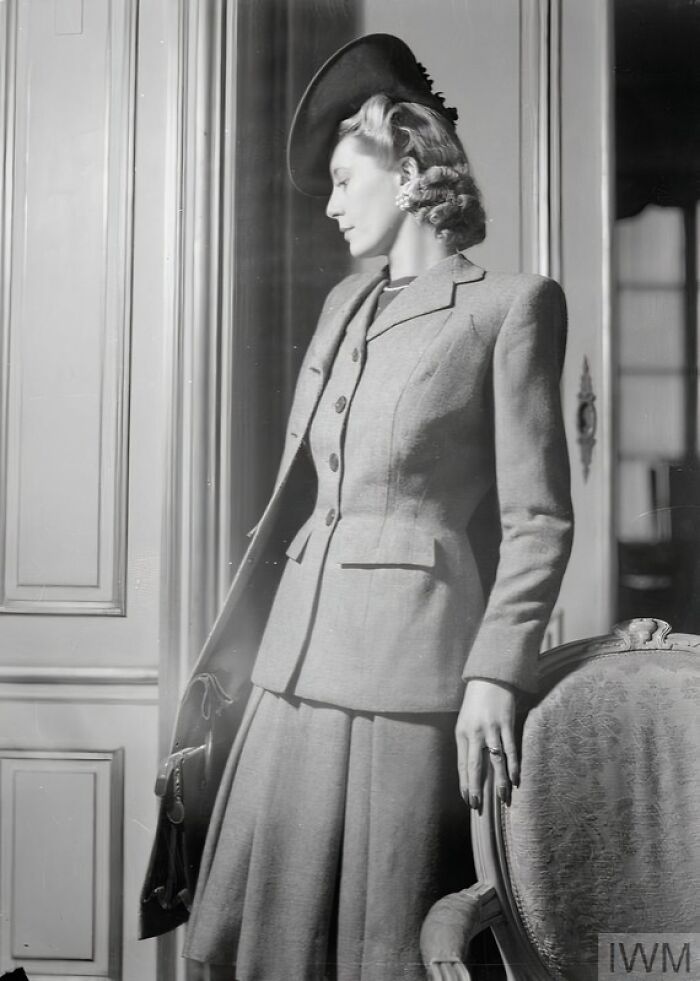 British woman modeling tailored outfit and hat, showcasing how British women kept their style during WWII restrictions.