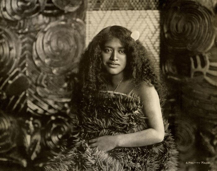 Portrait of a young Māori woman in traditional attire, showcasing Māori life and culture from a century ago.