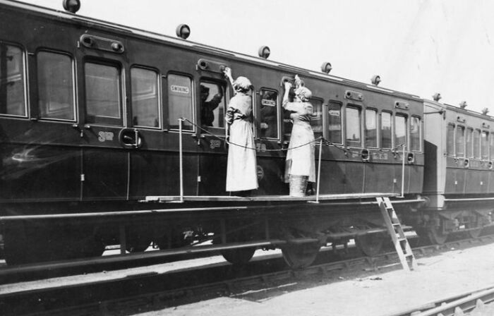 Two women cleaning the exterior of a train car, illustrating how women changed everything during WWI.