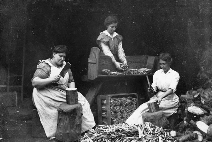 Women changing everything during WWI, working with tools and materials in a factory setting in a historic black and white photo.
