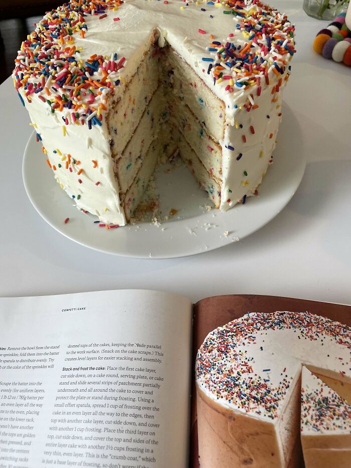 Layered confetti cake with white frosting and colorful sprinkles, showcasing gorgeous baked goods and baking skills.