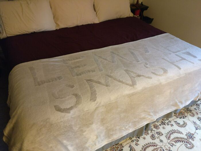 Bed with blanket showing words lesson smashed written by cleaning part of the fabric in a funny way people learned their lesson