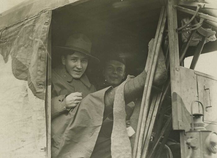 Two soldiers relaxing inside a WWI trench vehicle, revealing daily life beyond the WWI trenches in a candid moment.