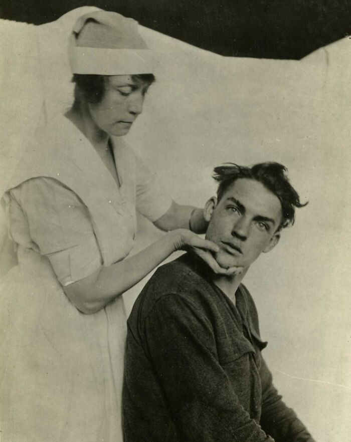 Nurse tending to wounded soldier, revealing daily life beyond the WWI trenches in a medical care setting.