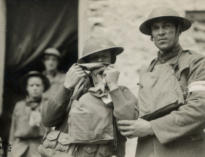 Two WWI soldiers wearing helmets and gas masks, showing daily life moments beyond the WWI trenches.