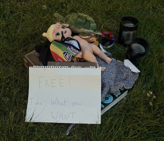 Pile of random items left with a free sign on grass, showing infuriating disregard for rules and etiquette in public spaces.