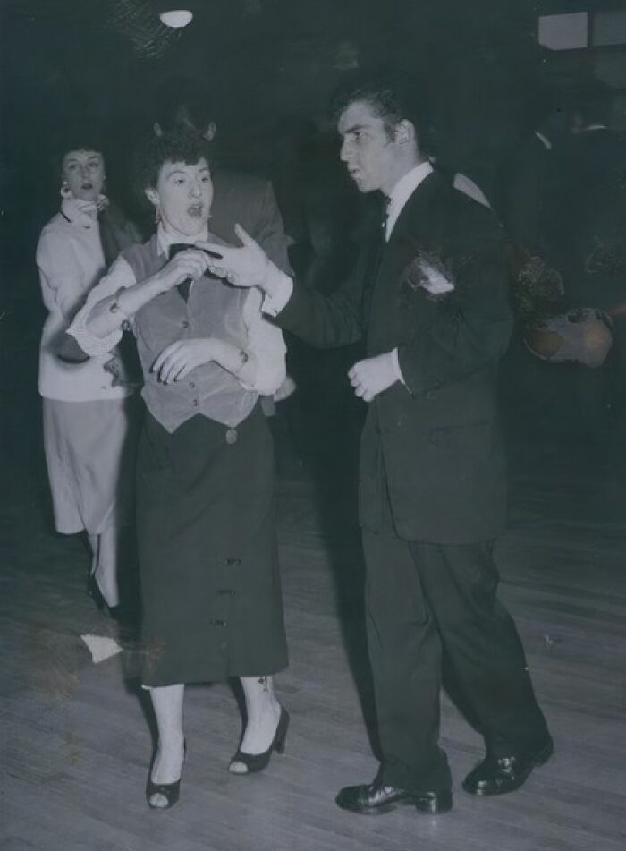 Young couple dancing in a vintage setting, dressed in classic 20th century Teddy Boy era fashion and style.