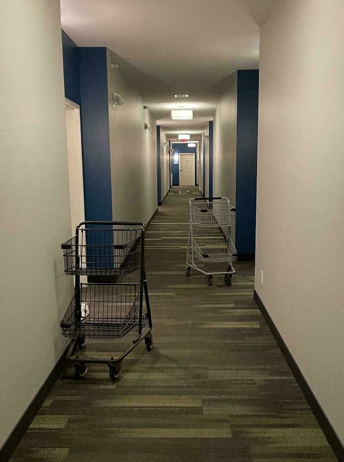 Two shopping carts left blocking a narrow hallway, showing disregard for rules and etiquette in a shared space.