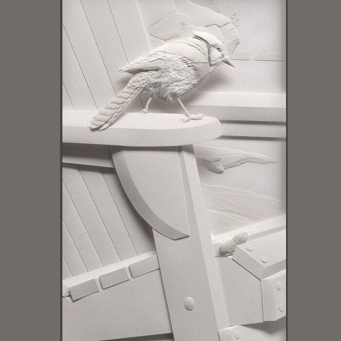 Realistic wildlife paper sculpture of a bird perched on a wooden structure, showcasing detailed feather and texture work.
