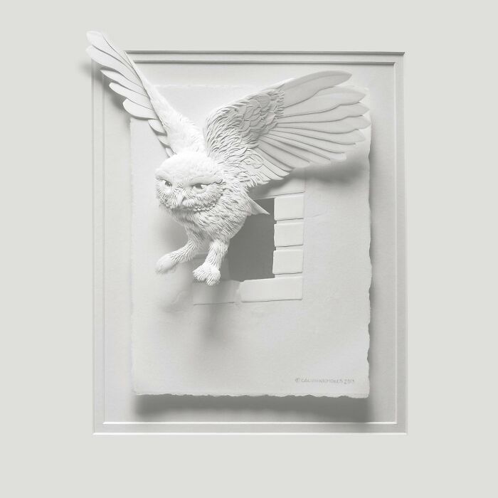 Paper wildlife sculpture of an owl flying through a window, showcasing stunningly realistic details and intricate paper art.