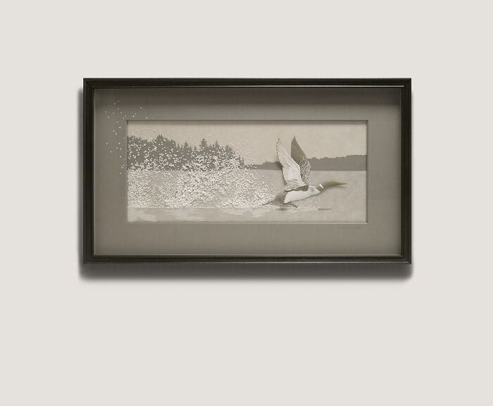 Framed wildlife sculpture of a bird taking flight created from layered paper with a forest and water background.