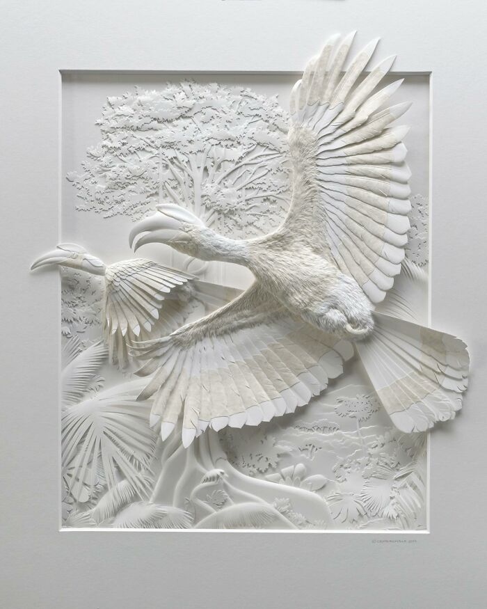 Realistic wildlife sculpture of a detailed bird in flight made from intricately crafted simple white paper layers.