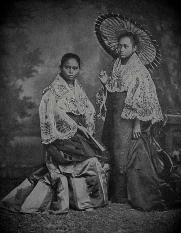 Two Filipino women in traditional 1890s clothing, showcasing cultural fashion contrasts in the Philippines during the 1890s.