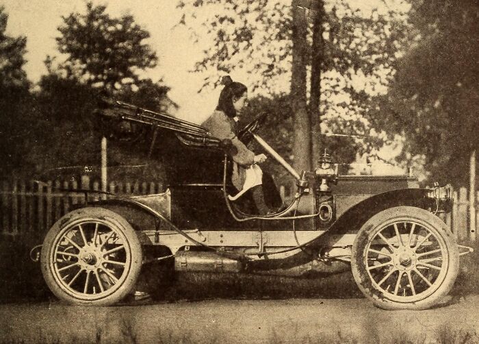Early 20th century woman driving one of the first cars, showcasing how wild the first cars really were 100 years ago.