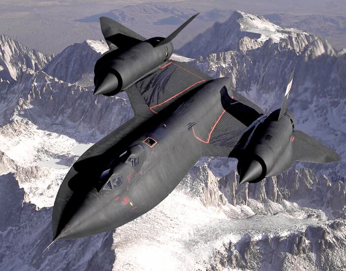 Black military aircraft flying over snowy mountain range, showcasing record-breaking inventions that move at mind-blowing speeds.